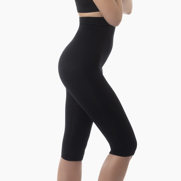 Right side view of women’s black high-waist anti-cellulite capri shapewear worn by model