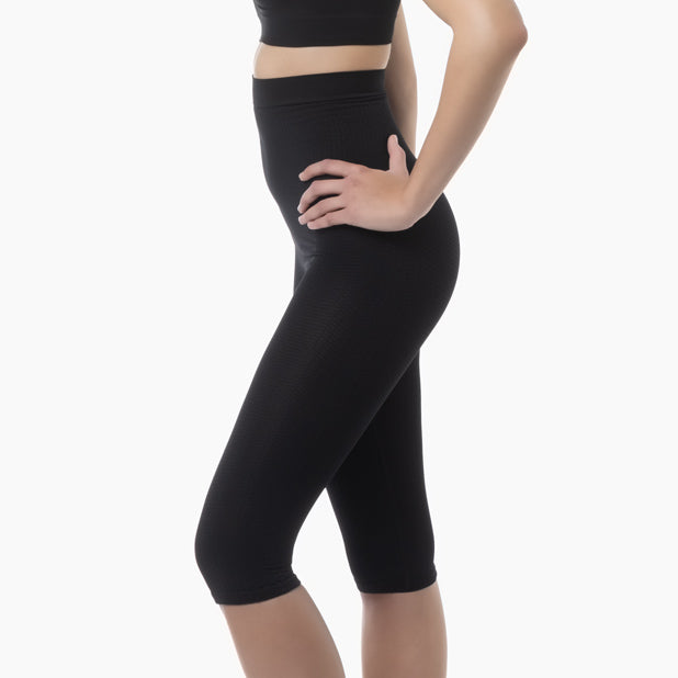 Left side view of women’s black high-waist anti-cellulite capri shapewear worn by model