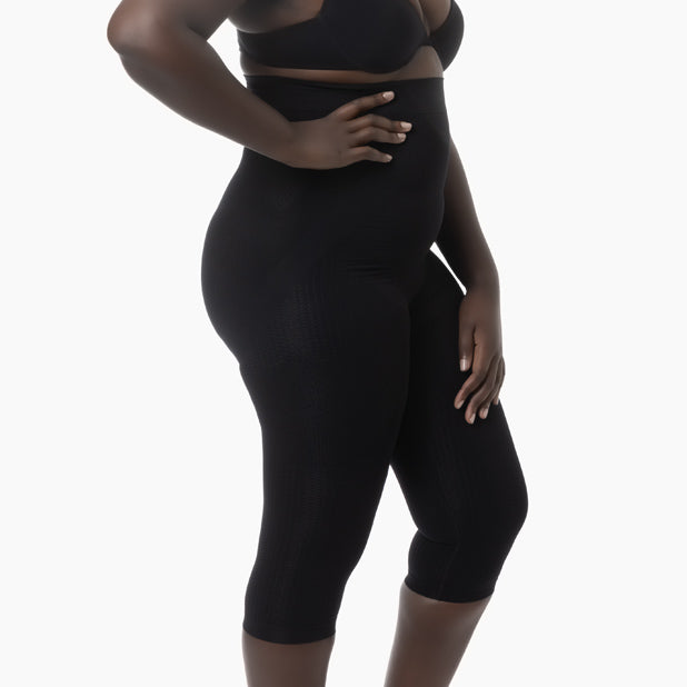 Right side view of women’s black high-waist capri shapewear with push-up and anti-cellulite control worn by curvy model