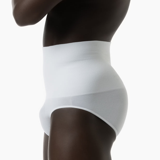 Left side view of men’s white tummy control shapewear brief worn by model