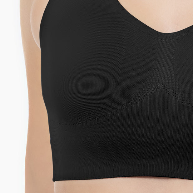 Front detail of black shapewear bra with wide shoulder straps worn by model