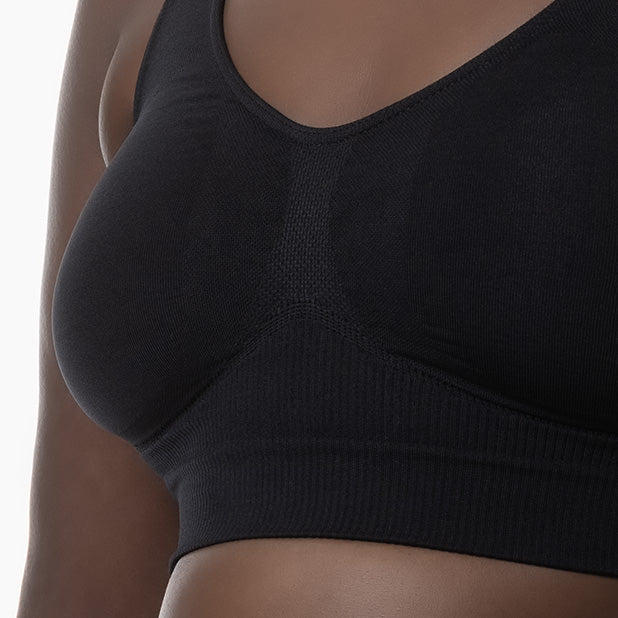 Front detail of black shapewear bra with wide shoulder straps worn by curvy model