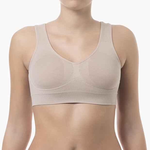 Front view of powder shapewear bra with wide shoulder straps worn by model