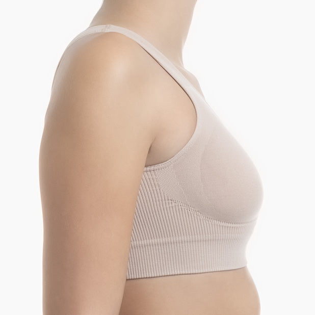 Right side view of powder shapewear bra with wide shoulder straps worn by model