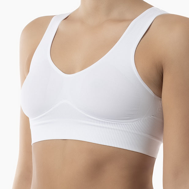 Left side view of white shapewear bra with wide shoulder straps worn by model