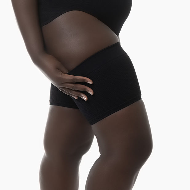 Right side view of women’s black anti-cellulite thigh band worn by model